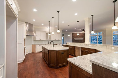 Eat-in kitchen - huge transitional u-shaped dark wood floor and brown floor eat-in kitchen idea in Chicago with an undermount sink, raised-panel cabinets, dark wood cabinets, granite countertops, gray backsplash, stainless steel appliances, two islands and marble backsplash