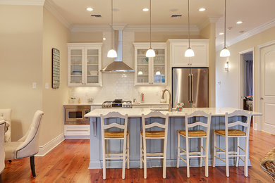 Inspiration for a timeless u-shaped medium tone wood floor kitchen remodel in New Orleans with a drop-in sink, beaded inset cabinets, white cabinets and an island