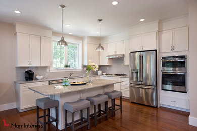 Example of a minimalist l-shaped brown floor kitchen design in Boston with an undermount sink, white cabinets, gray backsplash, stainless steel appliances, an island and ceramic backsplash