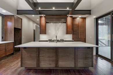 Trendy dark wood floor kitchen photo in Other with flat-panel cabinets, medium tone wood cabinets, white backsplash, an island, white countertops, an undermount sink and stainless steel appliances
