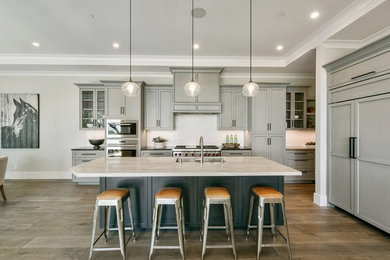 Large trendy l-shaped medium tone wood floor and brown floor eat-in kitchen photo in San Francisco with flat-panel cabinets, gray cabinets, marble countertops, white backsplash, stainless steel appliances, an island and white countertops