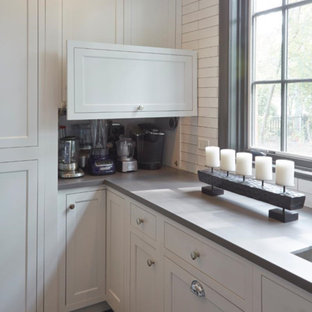 Design ideas for an expansive country kitchen pantry in Chicago with a double-bowl sink, recessed-panel cabinets, white cabinets, marble benchtops, white splashback, ceramic splashback, stainless steel appliances, porcelain floors, with island and brown floor.