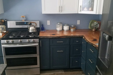 Modelo de cocina rústica con encimera de granito, salpicadero azul, electrodomésticos de acero inoxidable y encimeras marrones
