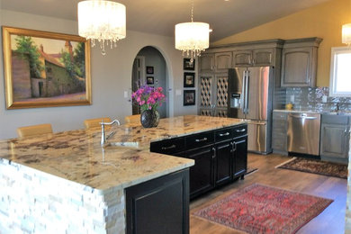 Eat-in kitchen - huge traditional l-shaped eat-in kitchen idea in Denver with distressed cabinets, granite countertops, gray backsplash and an island