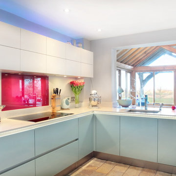 High gloss blue & matt white kitchen with red splash back