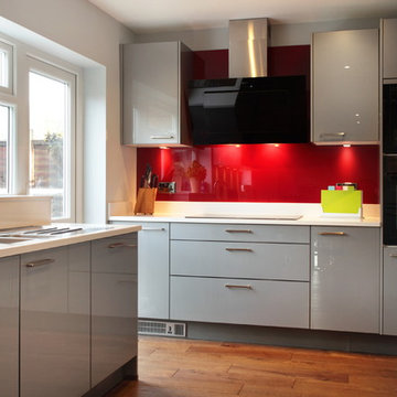 High gloss grey kitchen with red splashback