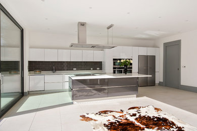 Foto de cocina contemporánea con armarios con paneles lisos, puertas de armario blancas y una isla