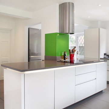 High gloss white contemporary kitchen with green splash back
