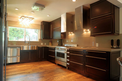 シアトルにある中くらいなコンテンポラリースタイルのおしゃれなキッチン (エプロンフロントシンク、落し込みパネル扉のキャビネット、濃色木目調キャビネット、シルバーの調理設備、無垢フローリング、茶色い床) の写真