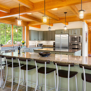 Immagine di una grande cucina american style con lavello sottopiano, ante in stile shaker, ante verdi, top in granito, elettrodomestici in acciaio inossidabile, pavimento in ardesia, 2 o più isole, pavimento grigio e travi a vista