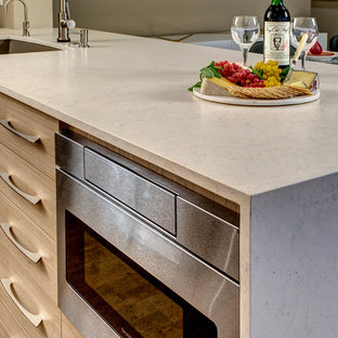 Zweizeilige, Kleine Moderne Wohnküche mit Unterbauwaschbecken, flächenbündigen Schrankfronten, braunen Schränken, Quarzwerkstein-Arbeitsplatte, Küchenrückwand in Beige, Küchengeräten aus Edelstahl, Korkboden und Halbinsel in Seattle
