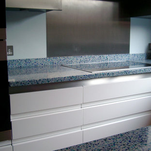 Mid-sized modern l-shaped kitchen in London with recycled glass benchtops, blue splashback, with island and blue benchtop.