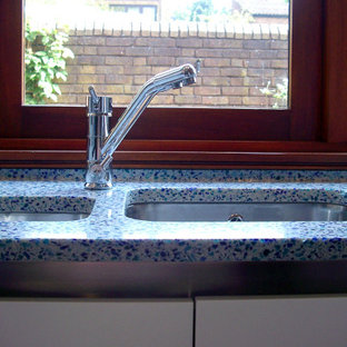 Design ideas for a mid-sized modern l-shaped kitchen in London with recycled glass benchtops, blue splashback, with island and blue benchtop.