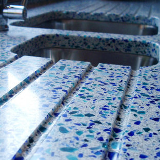 This is an example of a mid-sized modern l-shaped kitchen in London with recycled glass benchtops, blue splashback, with island and blue benchtop.