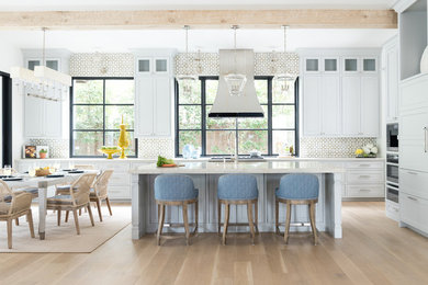 Inspiration for a l-shaped light wood floor and exposed beam eat-in kitchen remodel in Dallas with an undermount sink, marble countertops, ceramic backsplash, stainless steel appliances, an island and white countertops