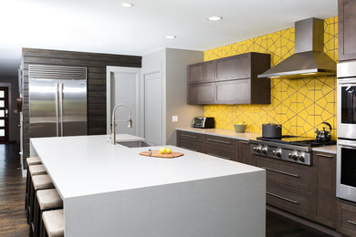 Photo of a large contemporary single-wall kitchen/diner in Dallas with a submerged sink, flat-panel cabinets, dark wood cabinets, engineered stone countertops, yellow splashback, ceramic splashback, stainless steel appliances and an island.