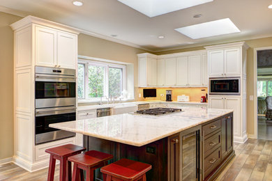 Example of a large transitional u-shaped kitchen design in Chicago with recessed-panel cabinets, white cabinets, onyx countertops and an island