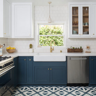 Mid-sized arts and crafts u-shaped separate kitchen in Los Angeles with a farmhouse sink, shaker cabinets, blue cabinets, quartz benchtops, white splashback, ceramic splashback, stainless steel appliances, cement tiles, no island and blue floor.