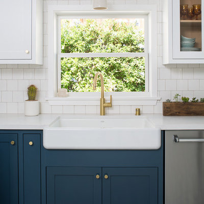 Example of a mid-sized arts and crafts u-shaped cement tile floor and blue floor enclosed kitchen design in Los Angeles with a farmhouse sink, shaker cabinets, blue cabinets, quartz countertops, white backsplash, ceramic backsplash, stainless steel appliances and no island