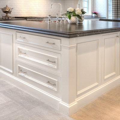 Example of a large transitional u-shaped eat-in kitchen design in Chicago with a farmhouse sink, recessed-panel cabinets, white cabinets, white backsplash, stainless steel appliances and two islands