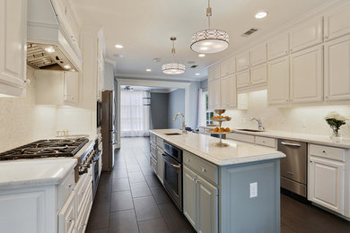Eat-in kitchen - large traditional galley ceramic tile eat-in kitchen idea in New Orleans with an undermount sink, raised-panel cabinets, white cabinets, quartzite countertops, white backsplash, stone tile backsplash, stainless steel appliances and an island