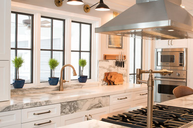 Mid-sized transitional galley dark wood floor and brown floor eat-in kitchen photo in Minneapolis with an undermount sink, flat-panel cabinets, white cabinets, marble countertops, white backsplash, marble backsplash, stainless steel appliances, an island and white countertops