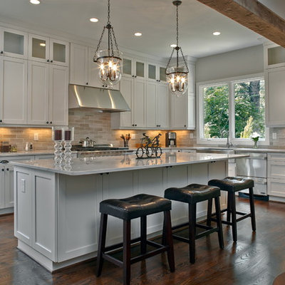 Example of a large classic l-shaped dark wood floor open concept kitchen design in Atlanta with a farmhouse sink, shaker cabinets, white cabinets, marble countertops, gray backsplash, stainless steel appliances, an island and white countertops
