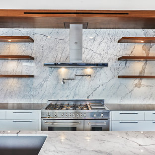 Inspiration for a mid-sized modern galley open concept kitchen remodel in Los Angeles with stainless steel appliances, an undermount sink, flat-panel cabinets, white cabinets, marble countertops, white backsplash and an island