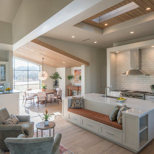 Contemporary open concept kitchen designs - Inspiration for a contemporary light wood floor and beige floor open concept kitchen remodel in Austin with a single-bowl sink, shaker cabinets, white cabinets, white backsplash, subway tile backsplash, stainless steel appliances and an island