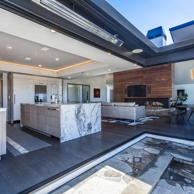 Inspiration for a modern dark wood floor kitchen remodel in San Francisco with a drop-in sink, flat-panel cabinets, medium tone wood cabinets, quartzite countertops, white backsplash, ceramic backsplash, paneled appliances and an island
