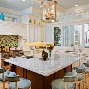 Неиссякаемый источник вдохновения для домашнего уюта: кухня в морском стиле с врезной раковиной, фасадами с утопленной филенкой, техникой из нержавеющей стали, паркетным полом среднего тона и островом