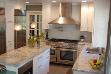 Inspiration for a mid-sized transitional l-shaped ceramic tile and beige floor eat-in kitchen remodel in Chicago with an undermount sink, flat-panel cabinets, white cabinets, marble countertops, gray backsplash, glass tile backsplash, stainless steel appliances and an island