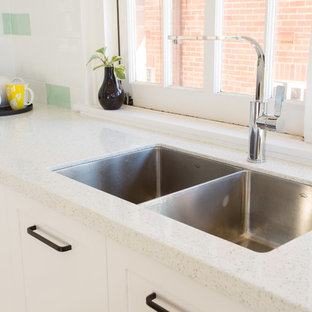 Mid-sized shabby-chic style u-shaped separate kitchen in Brisbane with a double-bowl sink, shaker cabinets, white cabinets, quartz benchtops, green splashback, subway tile splashback, white appliances, dark hardwood floors, no island, red floor and white benchtop.