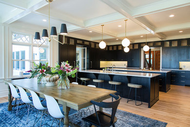 Huge transitional u-shaped medium tone wood floor and brown floor eat-in kitchen photo in Other with an undermount sink, shaker cabinets, black cabinets, quartzite countertops, white backsplash, subway tile backsplash, paneled appliances, two islands and white countertops