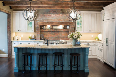 This is an example of a rustic l-shaped kitchen in Cincinnati with raised-panel cabinets and an island.