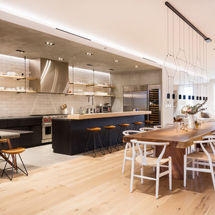 Esempio di una cucina ad ambiente unico industriale con nessun'anta, paraspruzzi bianco, elettrodomestici in acciaio inossidabile e parquet chiaro