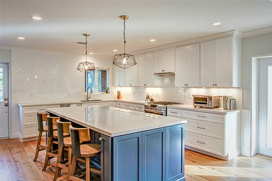 Large elegant galley medium tone wood floor eat-in kitchen photo in Phoenix with an undermount sink, shaker cabinets, white cabinets, granite countertops, white backsplash, subway tile backsplash, stainless steel appliances and an island