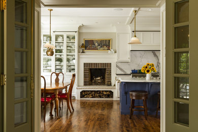 Klassisk inredning av ett avskilt, stort kök, med en dubbel diskho, luckor med profilerade fronter, vita skåp, marmorbänkskiva, vitt stänkskydd, stänkskydd i stenkakel, integrerade vitvaror, mellanmörkt trägolv och en köksö