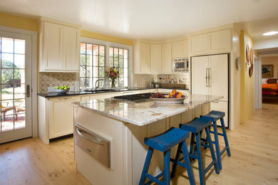 Ejemplo de cocinas en L clásica con armarios estilo shaker, puertas de armario blancas, salpicadero multicolor y electrodomésticos con paneles