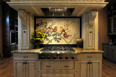 Inspiration for a large timeless galley medium tone wood floor enclosed kitchen remodel in Other with raised-panel cabinets, distressed cabinets, granite countertops, multicolored backsplash, mosaic tile backsplash and stainless steel appliances