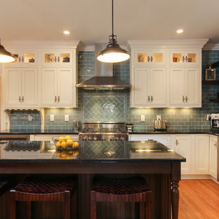 Inspiration for a large traditional l-shaped eat-in kitchen in Raleigh with an undermount sink, shaker cabinets, beige cabinets, granite benchtops, blue splashback, glass tile splashback, stainless steel appliances, medium hardwood floors and with island.