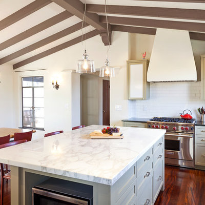 Eat-in kitchen - mediterranean u-shaped eat-in kitchen idea in Los Angeles with shaker cabinets, beige cabinets, white backsplash, subway tile backsplash and stainless steel appliances