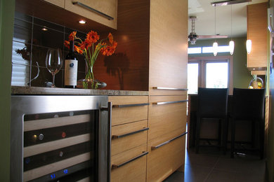 Example of a mid-sized minimalist u-shaped eat-in kitchen design in St Louis with flat-panel cabinets, medium tone wood cabinets, granite countertops, brown backsplash, glass tile backsplash, paneled appliances and a peninsula