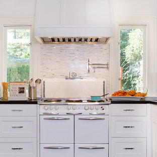 Example of a transitional kitchen design in Los Angeles with recessed-panel cabinets, white appliances, stone tile backsplash and white cabinets