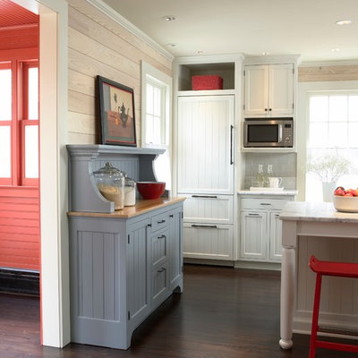 Open concept kitchen - small cottage dark wood floor open concept kitchen idea in Minneapolis with recessed-panel cabinets, white cabinets, marble countertops, gray backsplash, ceramic backsplash, paneled appliances and an island