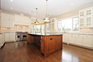 Enclosed kitchen - traditional u-shaped medium tone wood floor and brown floor enclosed kitchen idea in New York with an undermount sink, shaker cabinets, white cabinets, beige backsplash, porcelain backsplash, stainless steel appliances, an island and gray countertops