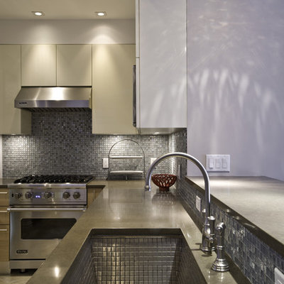 Example of a minimalist kitchen design in New York with stainless steel appliances, a single-bowl sink, flat-panel cabinets, medium tone wood cabinets, quartz countertops, mosaic tile backsplash and metallic backsplash