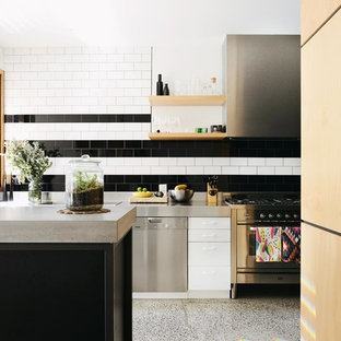 Photo of a contemporary kitchen in Melbourne with concrete benchtops, flat-panel cabinets, white cabinets, multi-coloured splashback, subway tile splashback and stainless steel appliances.