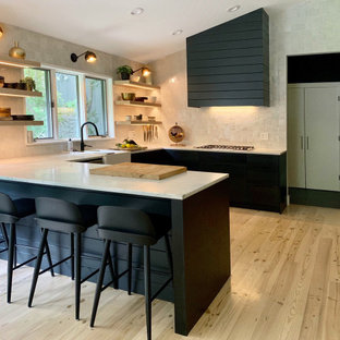 Large modern eat-in kitchen remodeling - Large minimalist u-shaped light wood floor and beige floor eat-in kitchen photo in New York with a farmhouse sink, flat-panel cabinets, black cabinets, marble countertops, white backsplash, terra-cotta backsplash, stainless steel appliances and white countertops