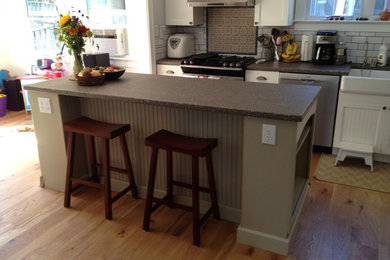 Example of a mid-sized classic medium tone wood floor and brown floor eat-in kitchen design in DC Metro with beaded inset cabinets, ceramic backsplash, a farmhouse sink, white backsplash and an island